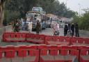 Police officers stand guard on an entry point to motorway leading to Islamabad, which has been closed by authorities due to a planned rally by supporters of imprisoned former Prime Minister Imran Khan’s Pakistan Tehreek-e-Insaf party, in Lahore (KM