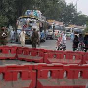 Police officers stand guard on an entry point to motorway leading to Islamabad, which has been closed by authorities due to a planned rally by supporters of imprisoned former Prime Minister Imran Khan’s Pakistan Tehreek-e-Insaf party, in Lahore (KM