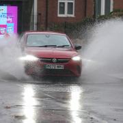 A vehicle is driven through floodwater after heavy rain in Warwick (Jacob King/PA)