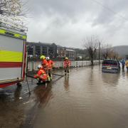 Firefighters pumping water from a street by the River Taff in Pontypridd, Wales, following flooding (George Thompson/PA)